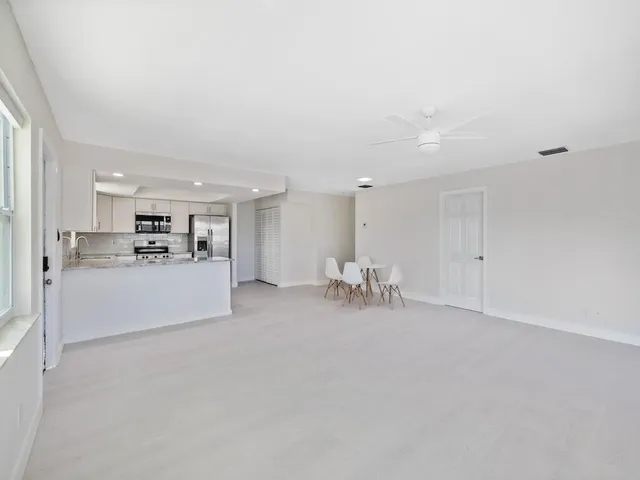 a kitchen with stainless steel appliances white cabinets and a stove top oven
