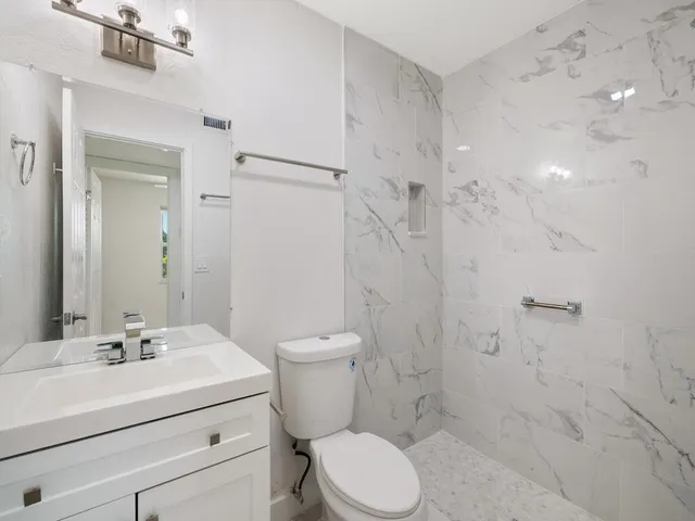 a kitchen with stainless steel appliances kitchen island a refrigerator sink and cabinets