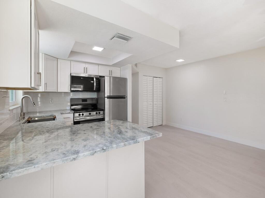741 Hernando Street Fort Pierce, FL 34949 - Photo 42 of 65 a kitchen with stainless steel appliances a refrigerator a sink a stove a microwave and cabinets