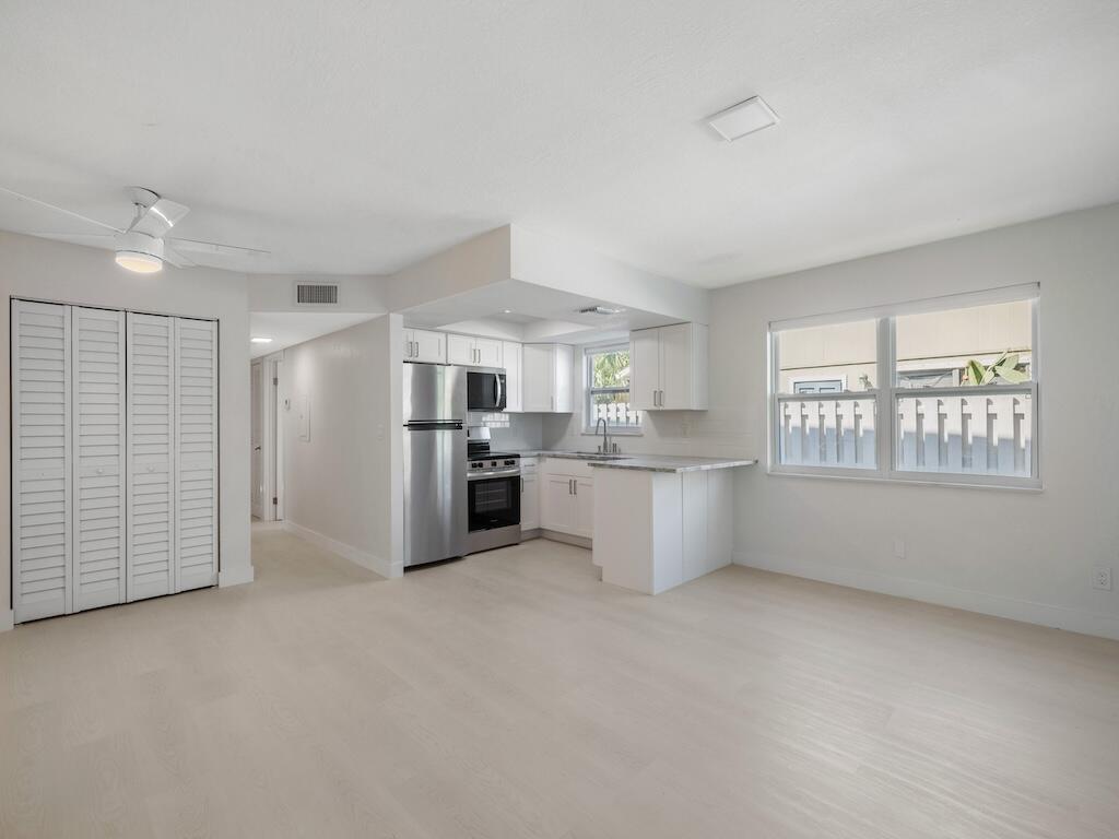 741 Hernando Street Fort Pierce, FL 34949 - Photo 51 of 65 a kitchen with stainless steel appliances kitchen island a refrigerator sink and cabinets