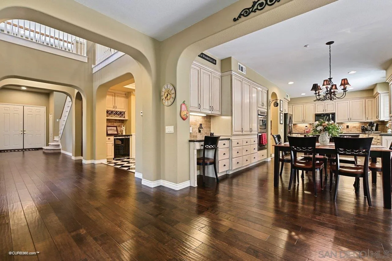 16658 Deer Ridge Road San Diego, CA 92127 - Photo 4 of 44 a view of a dining room and livingroom with furniture wooden floor a chandelier