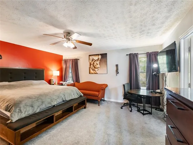 a bedroom with a bed a large window and furniture