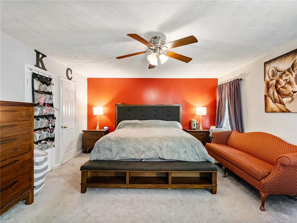 443 Rhett Drive Loganville, GA 30052 - Photo 15 of 28 a spacious bedroom with a bed and a chandelier