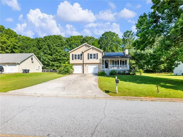 a view of a house with a big yard and large trees