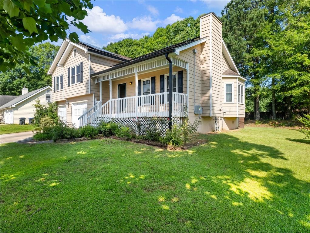 443 Rhett Drive Loganville, GA 30052 - Photo 24 of 28 a front view of a house with a yard and potted plants