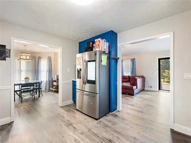 a living room with furniture wooden floor and a refrigerator