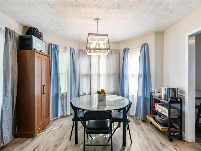 a dining room with furniture window wooden floor and a chandelier