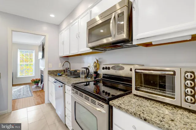 a kitchen with stainless steel appliances granite countertop a stove and a microwave