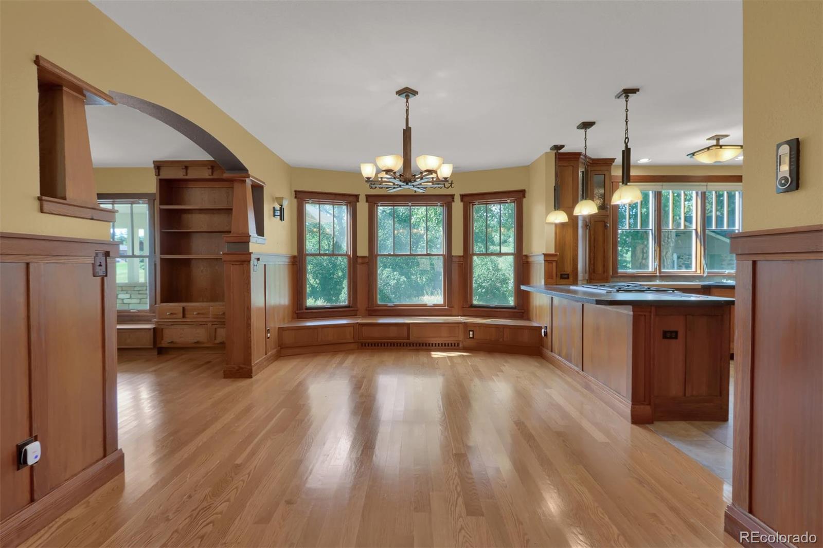 3045 Hay Creek Road Colorado Springs, CO 80921 - Photo 11 of 40 a view of a room with wooden floor a ceiling fan and windows
