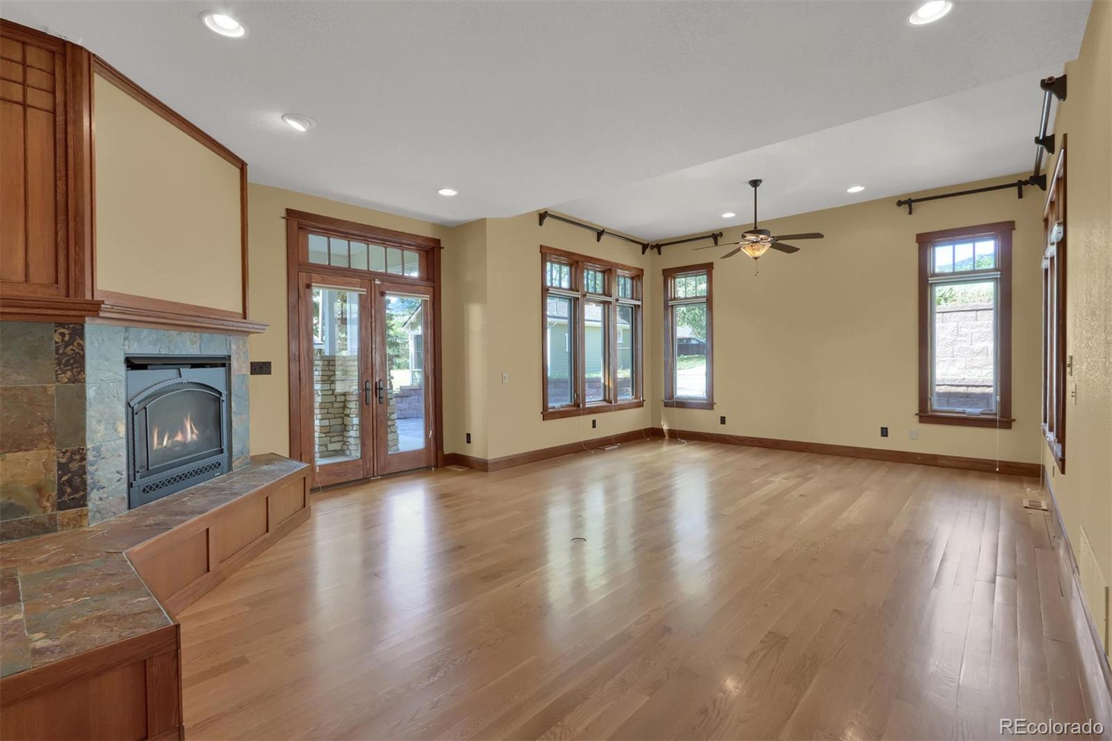 3045 Hay Creek Road Colorado Springs, CO 80921 - Photo 18 of 40 an empty room with wooden floor and a fireplace