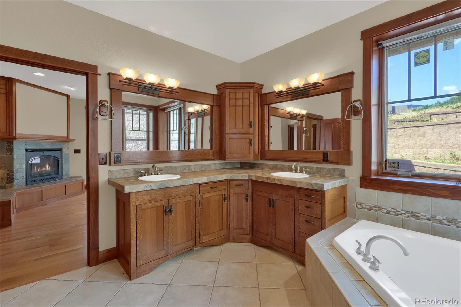 3045 Hay Creek Road Colorado Springs, CO 80921 - Photo 21 of 40 a spacious bathroom with a granite countertop sink and mirror with bathtub
