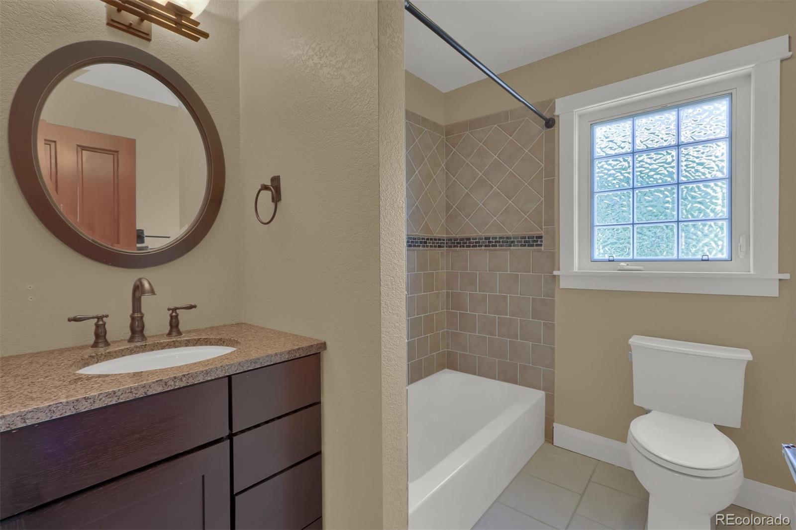 3045 Hay Creek Road Colorado Springs, CO 80921 - Photo 25 of 40 a bathroom with a sink a toilet and a mirror