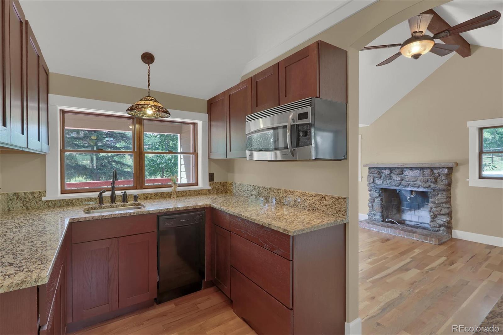 3045 Hay Creek Road Colorado Springs, CO 80921 - Photo 31 of 40 a kitchen with a sink stove and microwave