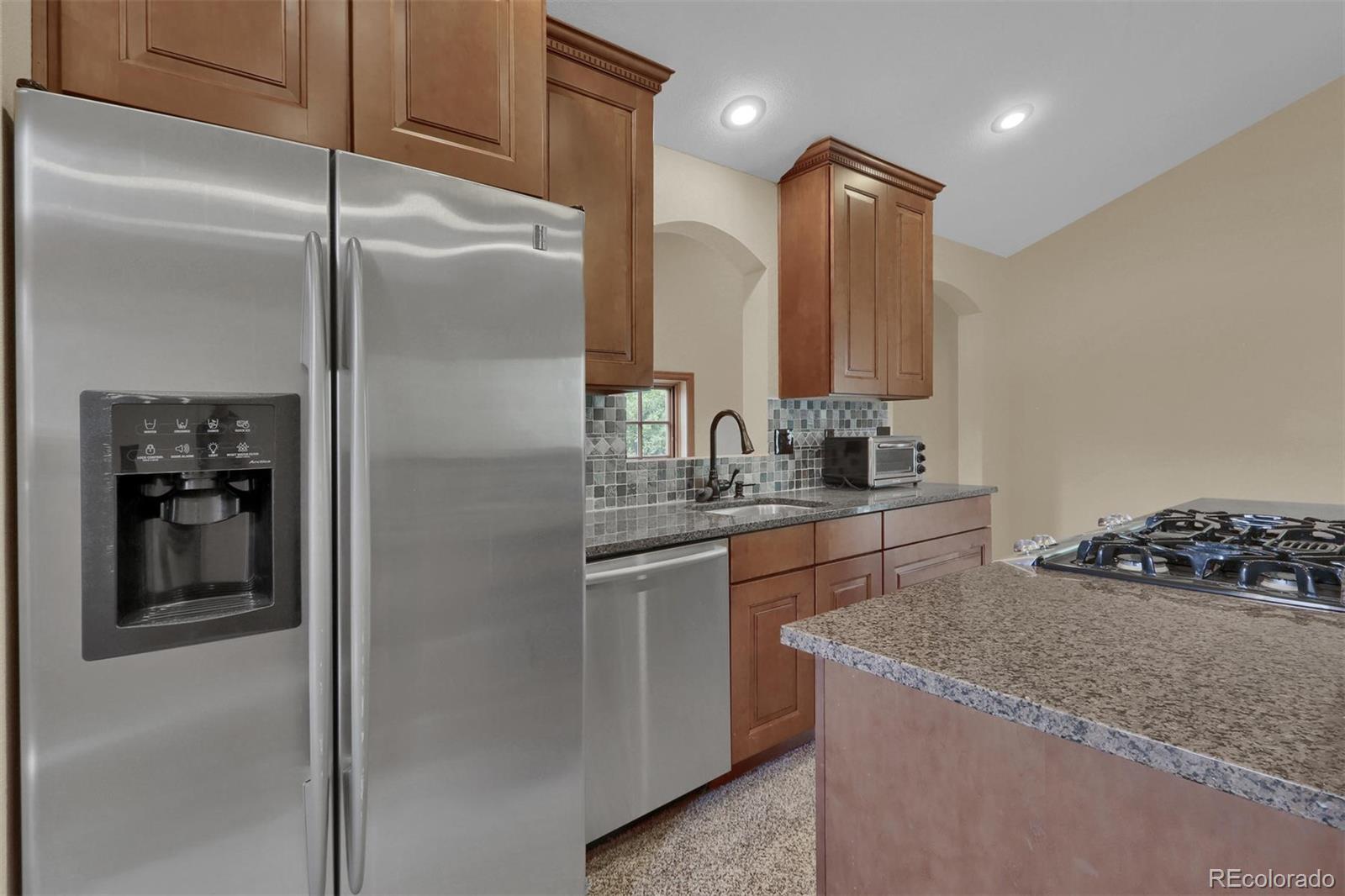 3045 Hay Creek Road Colorado Springs, CO 80921 - Photo 36 of 40 a kitchen with stainless steel appliances granite countertop a refrigerator and a sink