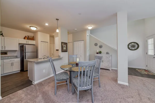 a kitchen with a dining table chairs refrigerator and cabinets