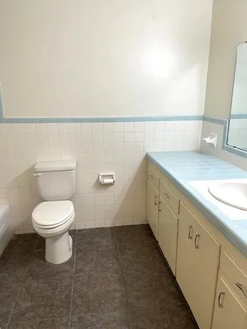 a bathroom with a toilet sink and mirror