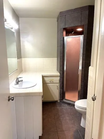 a bathroom with a sink a toilet and shower
