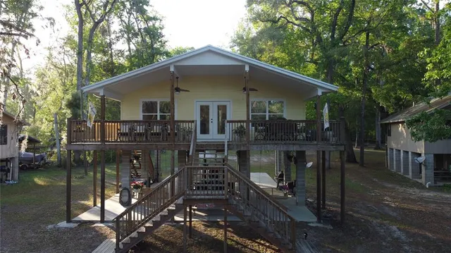 a front view of house with yard and trees in the background