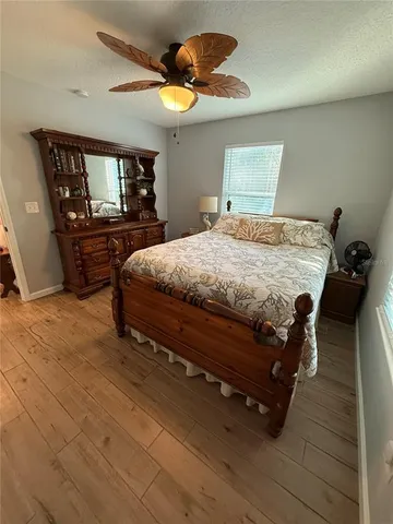 a bedroom with a bed and wooden floor