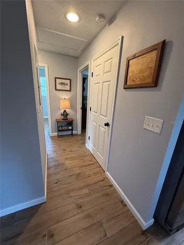 a view of a hallway with wooden floor and furniture