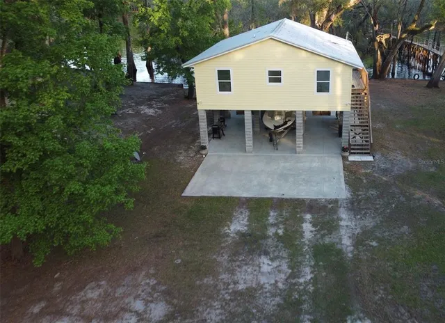 a view of a backyard with table and chairs with plants and trees