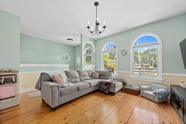 a living room with furniture chandelier and a window