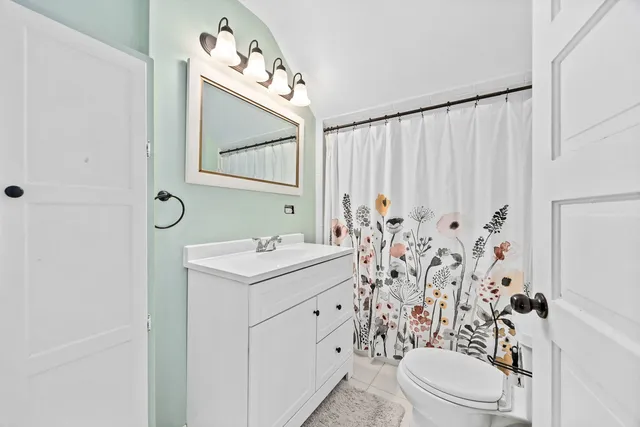 a view of a house with a yard and large tree