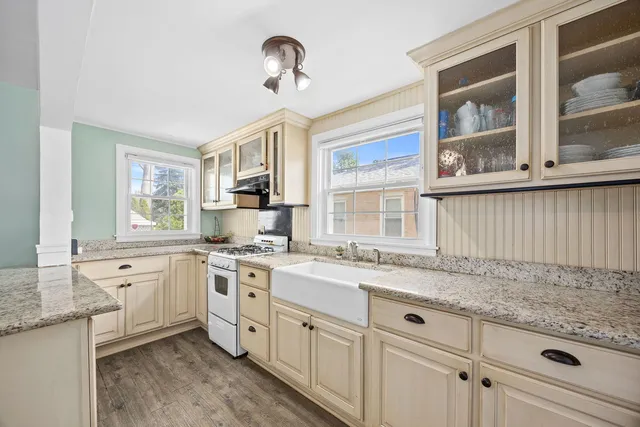 a kitchen with granite countertop stainless steel appliances a stove sink and cabinets
