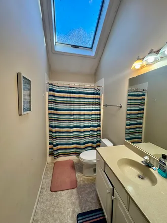 a bathroom with a granite countertop sink and a shower