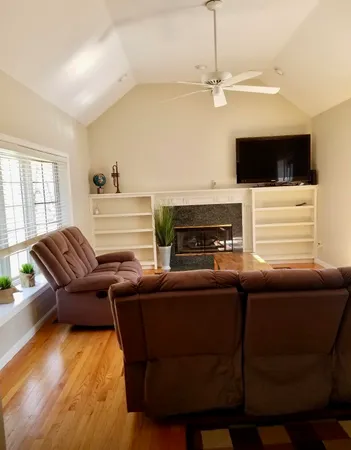a living room with furniture a flat screen tv and a fireplace