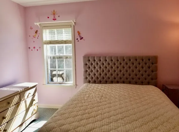 a large bed sitting in a bedroom next to a window