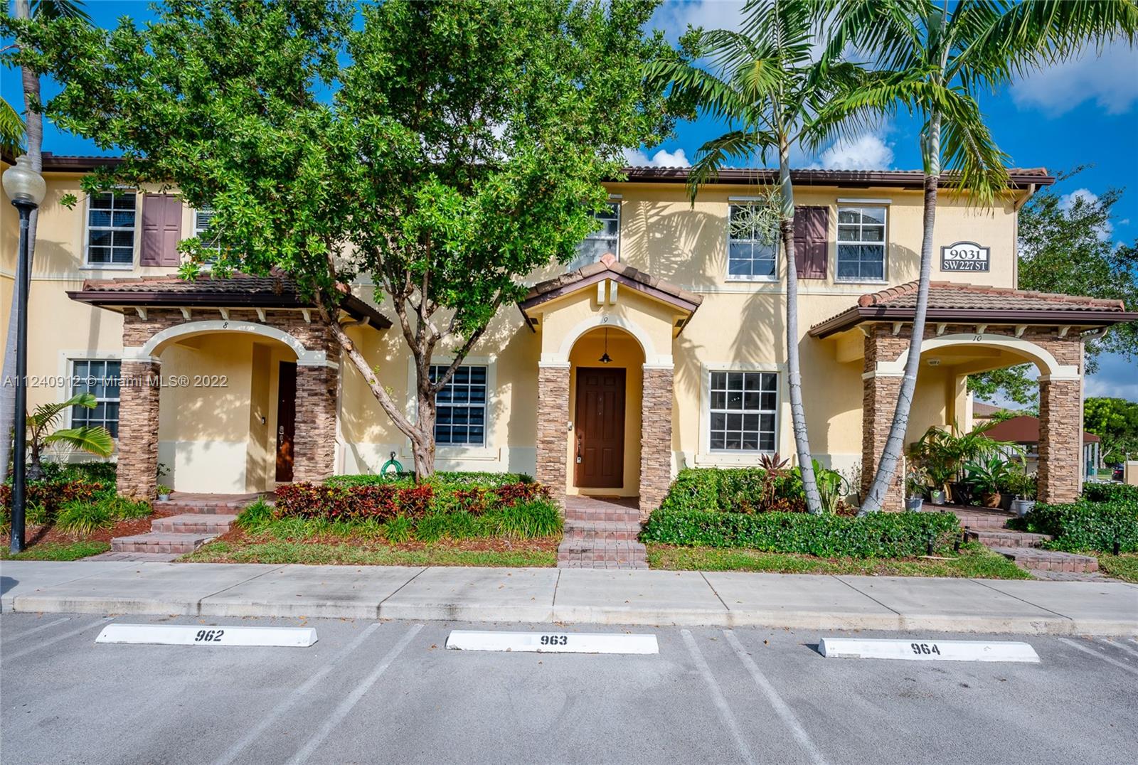 9031 Southwest 227th Street, Unit 9 Cutler Bay, FL 33190 - Photo 1 of 20 a front view of a house with a garden