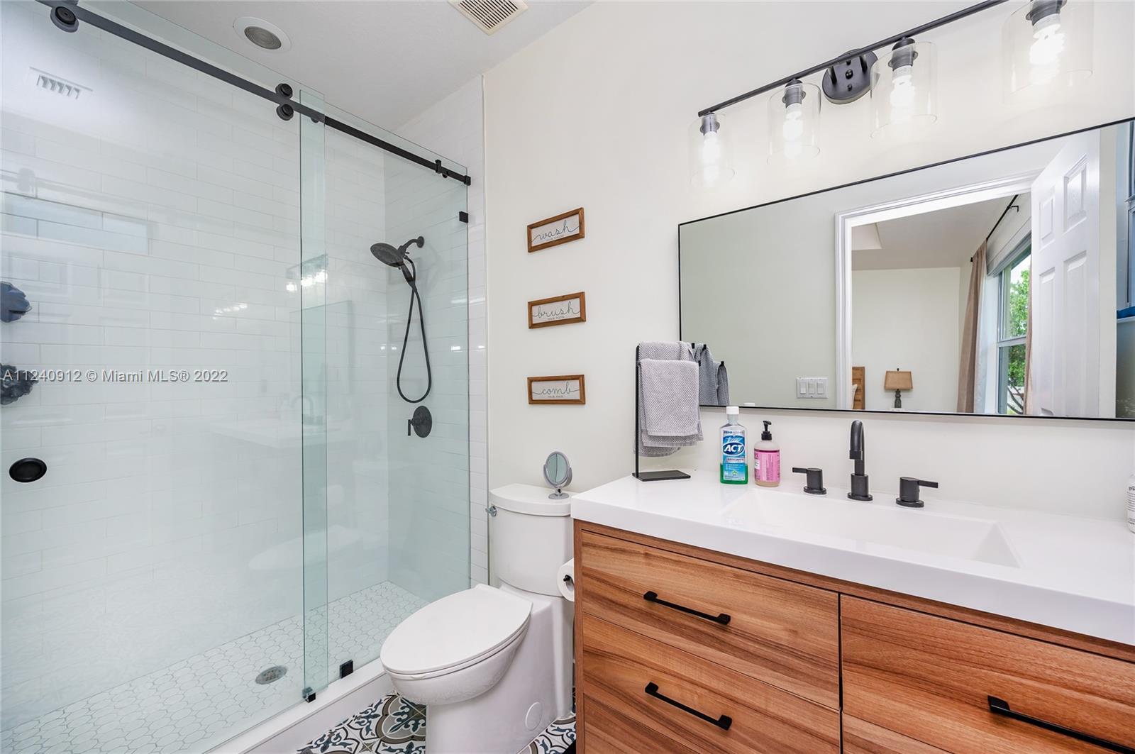 9031 Southwest 227th Street, Unit 9 Cutler Bay, FL 33190 - Photo 14 of 20 a bathroom with a sink a toilet and shower