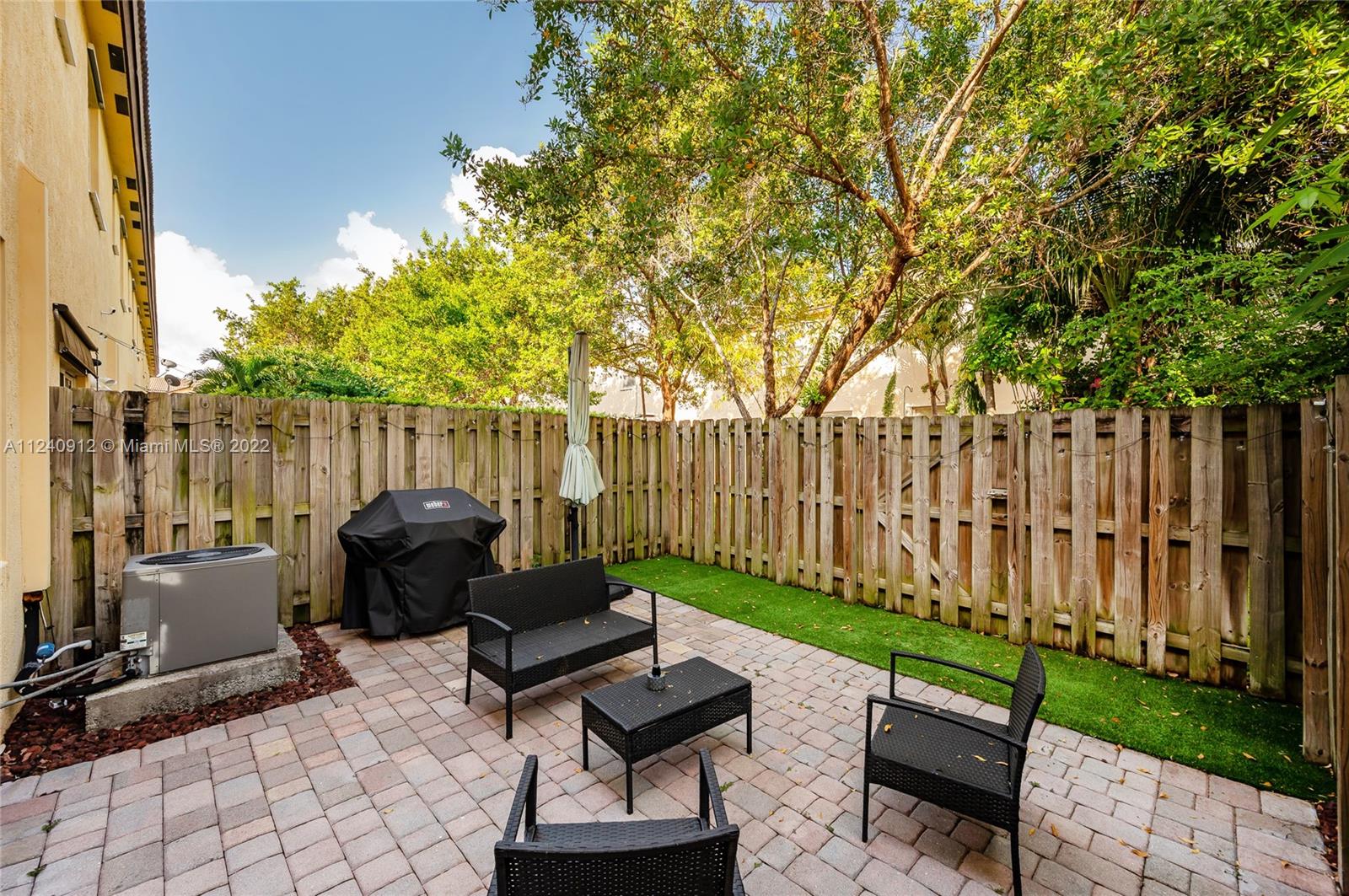 9031 Southwest 227th Street, Unit 9 Cutler Bay, FL 33190 - Photo 18 of 20 a view of a chairs and tables in the back yard of the house