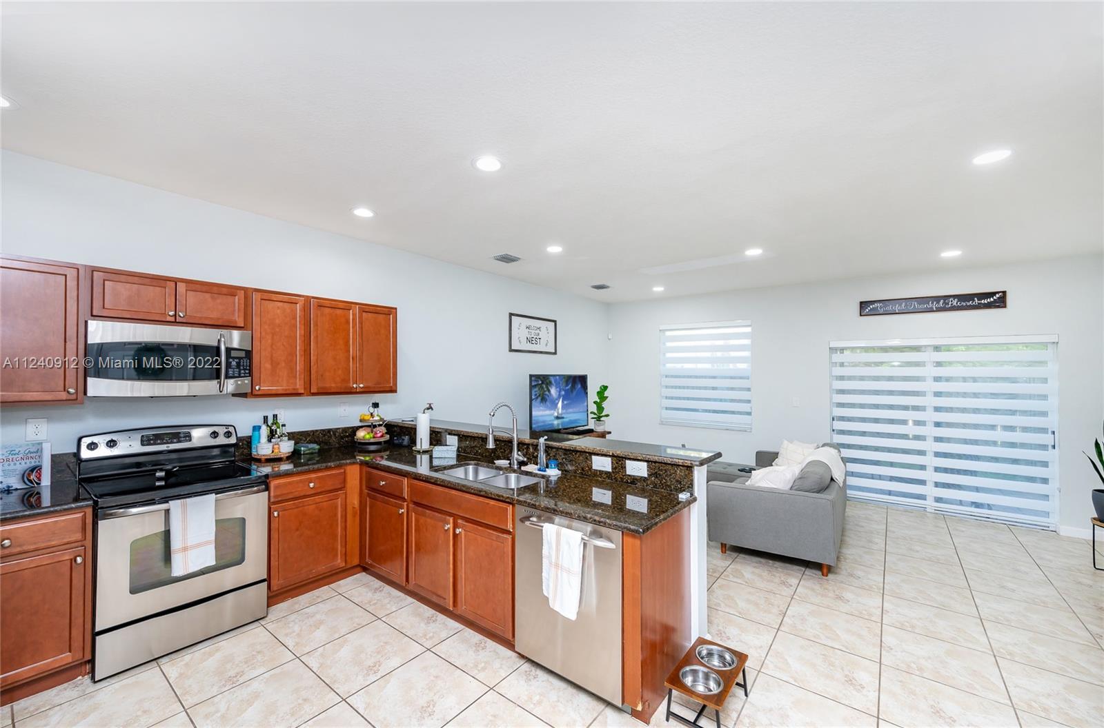 9031 Southwest 227th Street, Unit 9 Cutler Bay, FL 33190 - Photo 4 of 20 a kitchen with a sink a counter top space cabinets and stainless steel appliances
