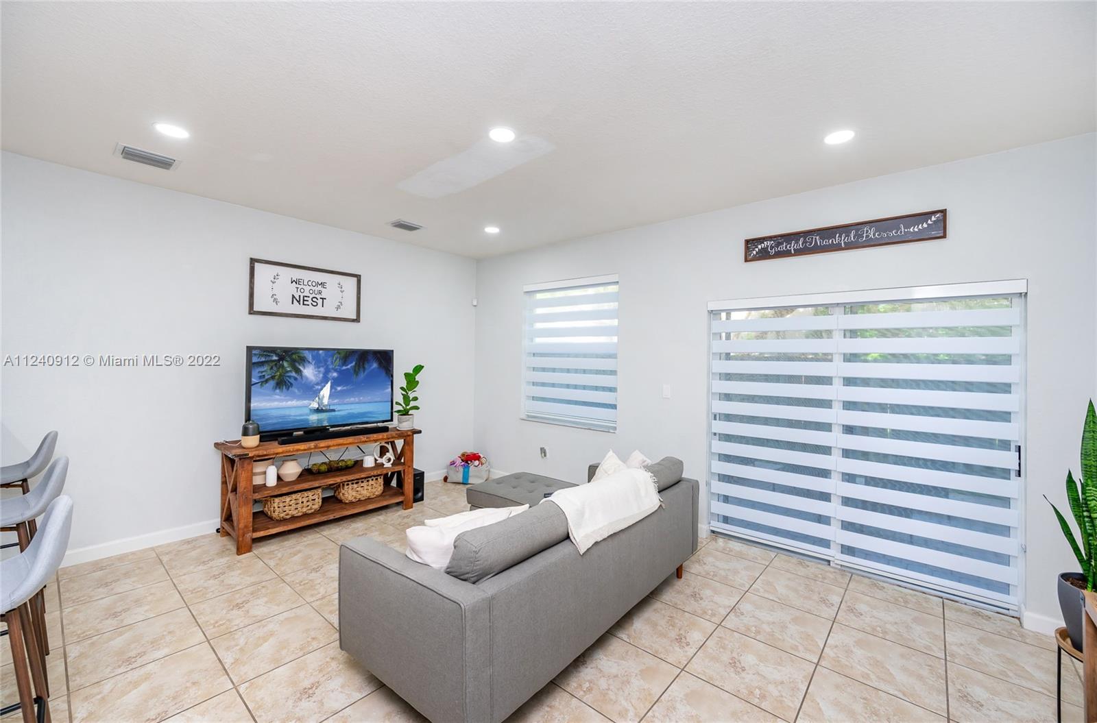 9031 Southwest 227th Street, Unit 9 Cutler Bay, FL 33190 - Photo 6 of 20 a living room with furniture and a flat screen tv