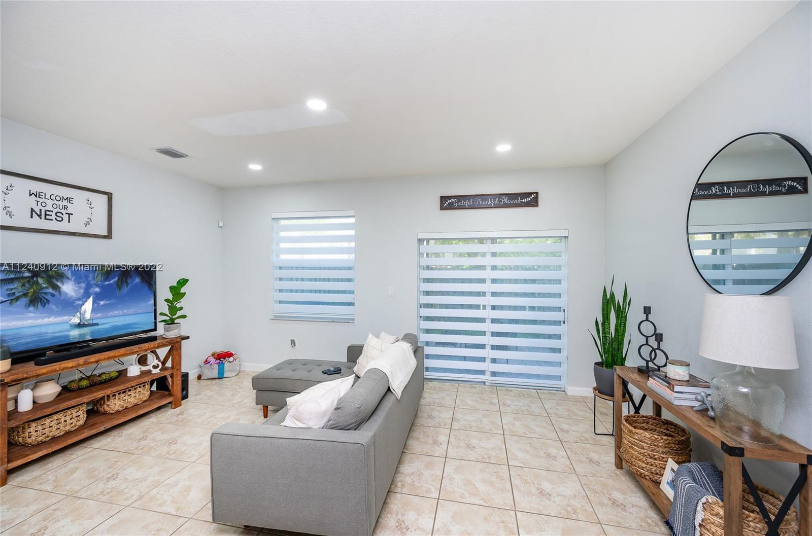 9031 Southwest 227th Street, Unit 9 Cutler Bay, FL 33190 - Photo 7 of 20 a living room with furniture and a flat screen tv