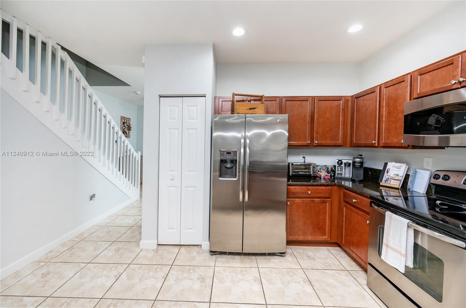 9031 Southwest 227th Street, Unit 9 Cutler Bay, FL 33190 - Photo 9 of 20 a kitchen with stainless steel appliances granite countertop a refrigerator a sink a stove top oven and cabinets