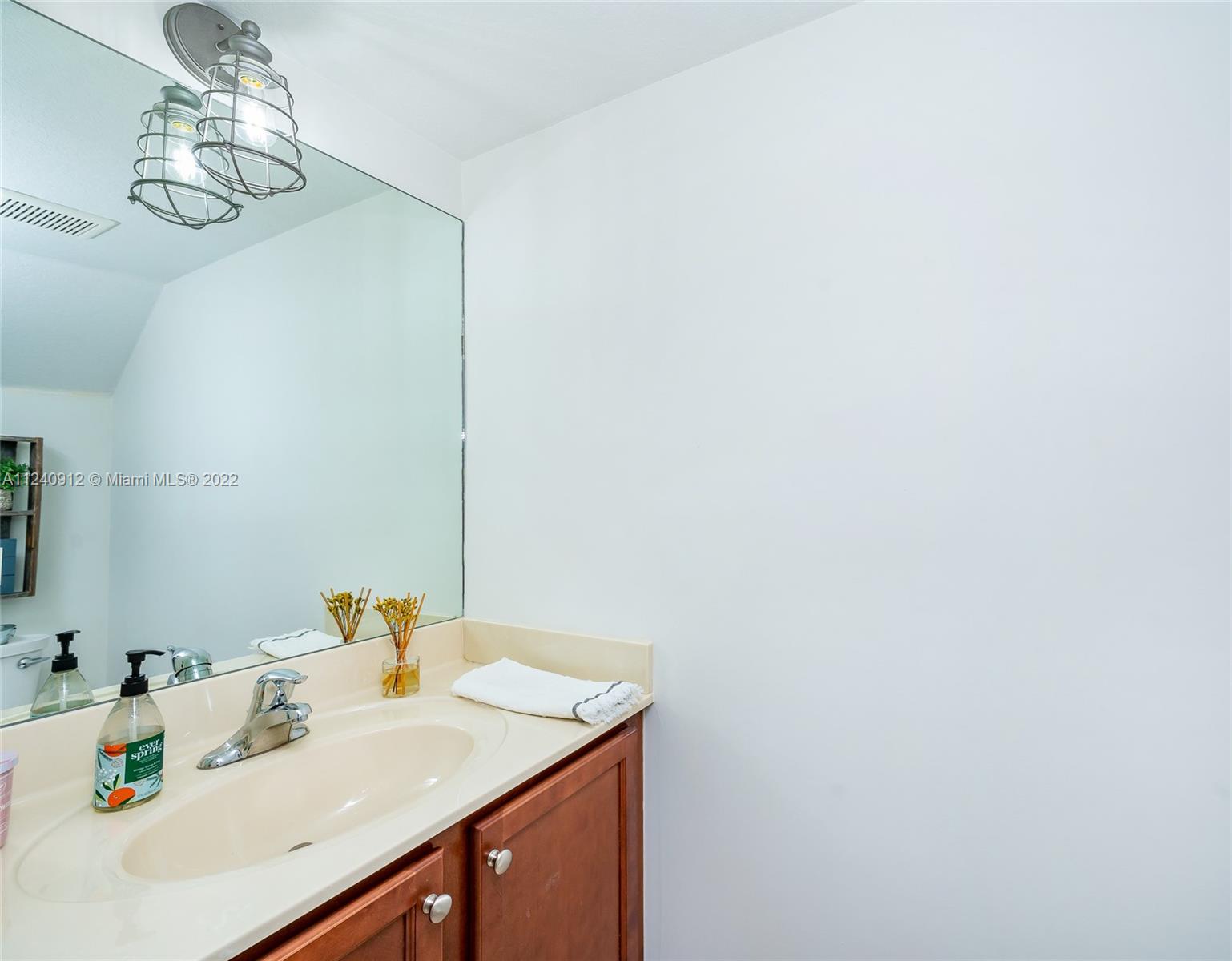 9031 Southwest 227th Street, Unit 9 Cutler Bay, FL 33190 - Photo 10 of 20 a bathroom with a sink and a mirror