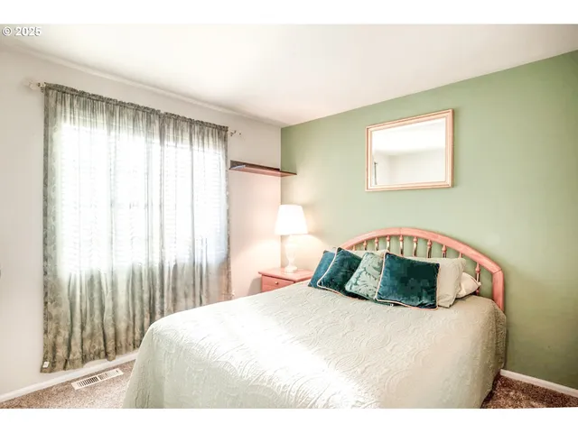 a living room with a bed mirror and a window
