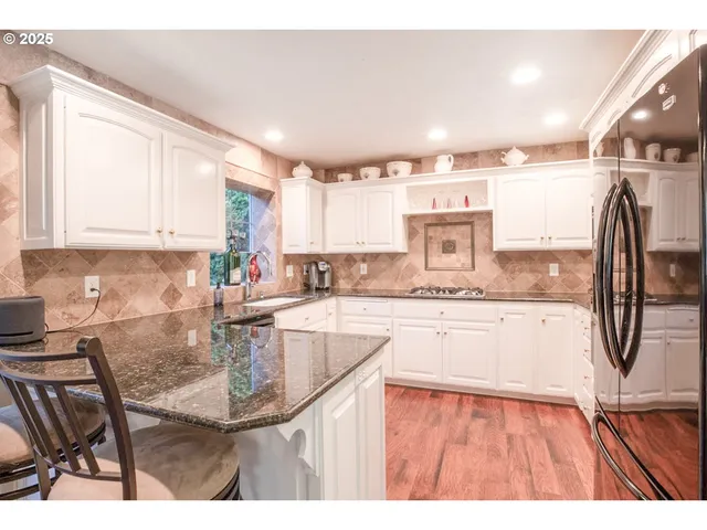 a kitchen with stainless steel appliances kitchen island granite countertop a sink and cabinets