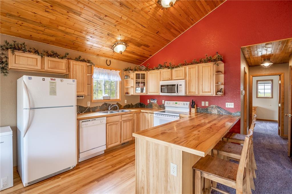 95 Ute Way Como, CO 80432 - Photo 2 of 27 a kitchen with granite countertop a refrigerator a stove a sink dishwasher and white cabinets with wooden floor