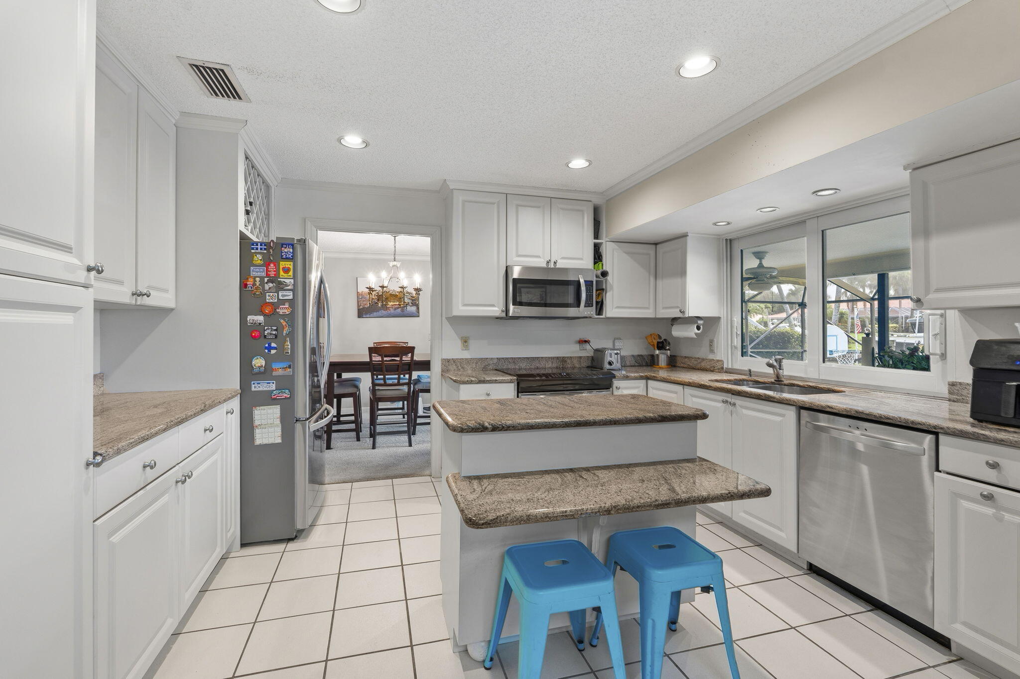 3374 Southeast Fairway East Stuart, FL 34997 - Photo 15 of 65 a kitchen with stainless steel appliances granite countertop a stove top oven a sink a refrigerator and cabinets