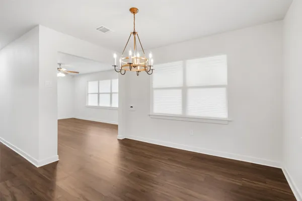 a view of a livingroom with wooden floor a chandelier