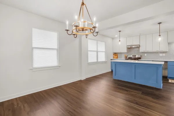 a kitchen with stainless steel appliances granite countertop a sink cabinets wooden floor and a window