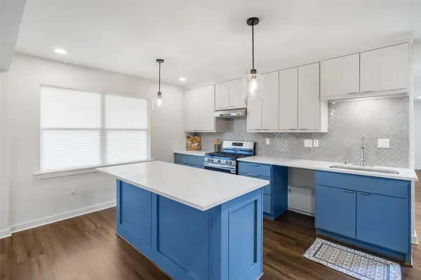 a kitchen with wooden cabinets a sink a center island and a window