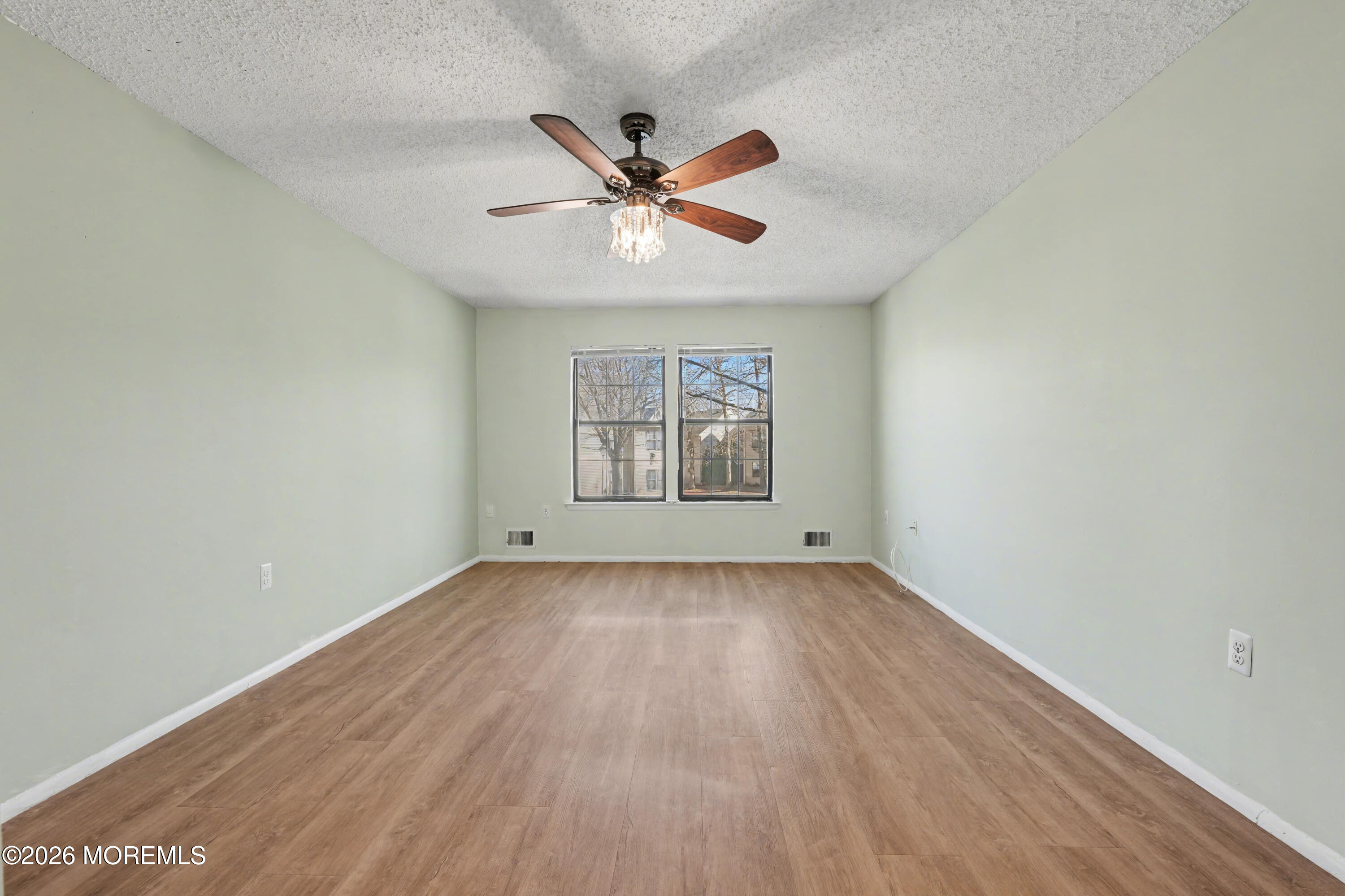 1807 Lilly Lane Jackson, NJ 08527 - Photo 16 of 31 an empty room with wooden floor chandelier fan and windows