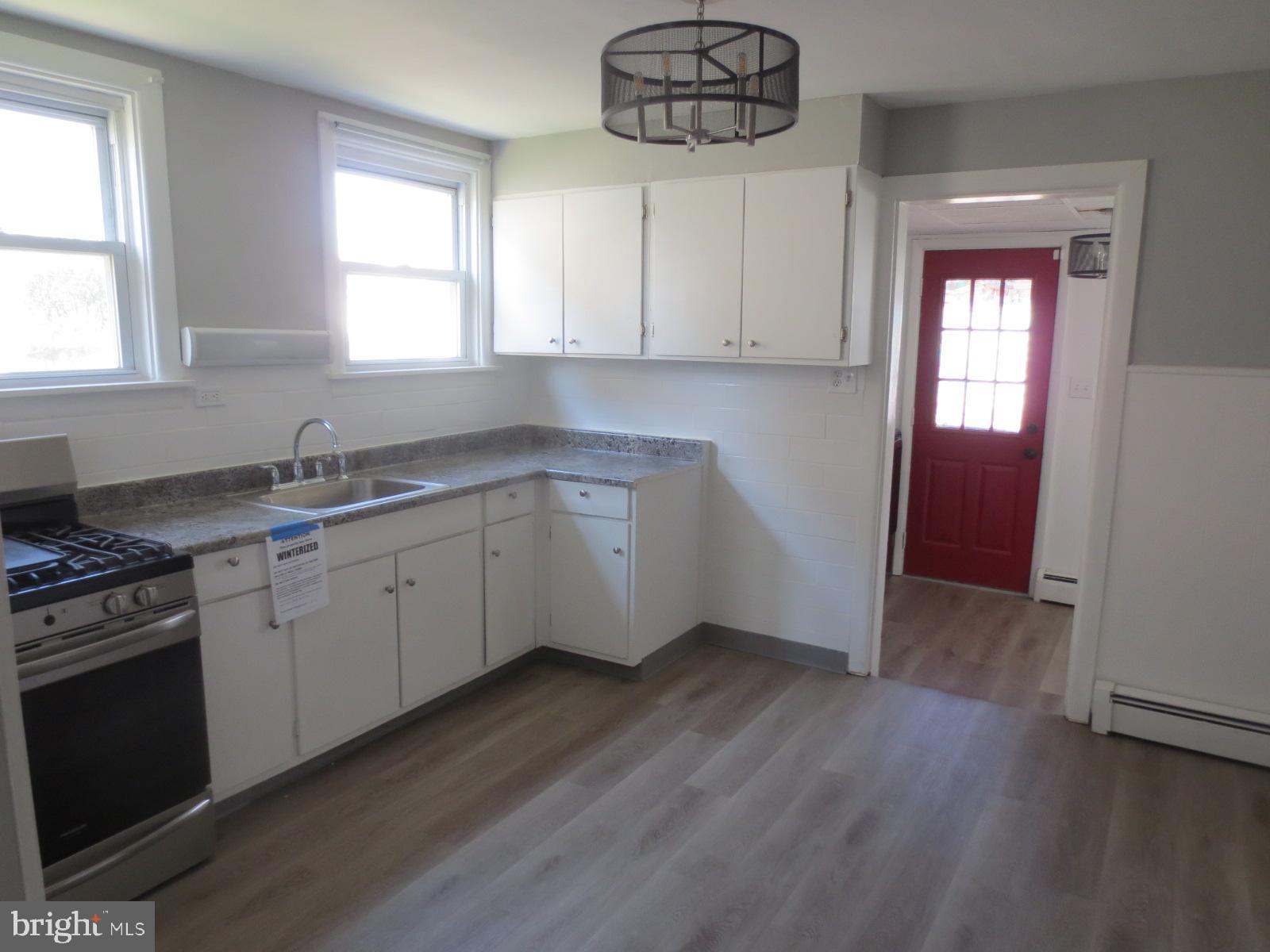 617 Benson Street Philadelphia, PA 19111 - Photo 12 of 37 a kitchen with a sink dishwasher a stove and white cabinets