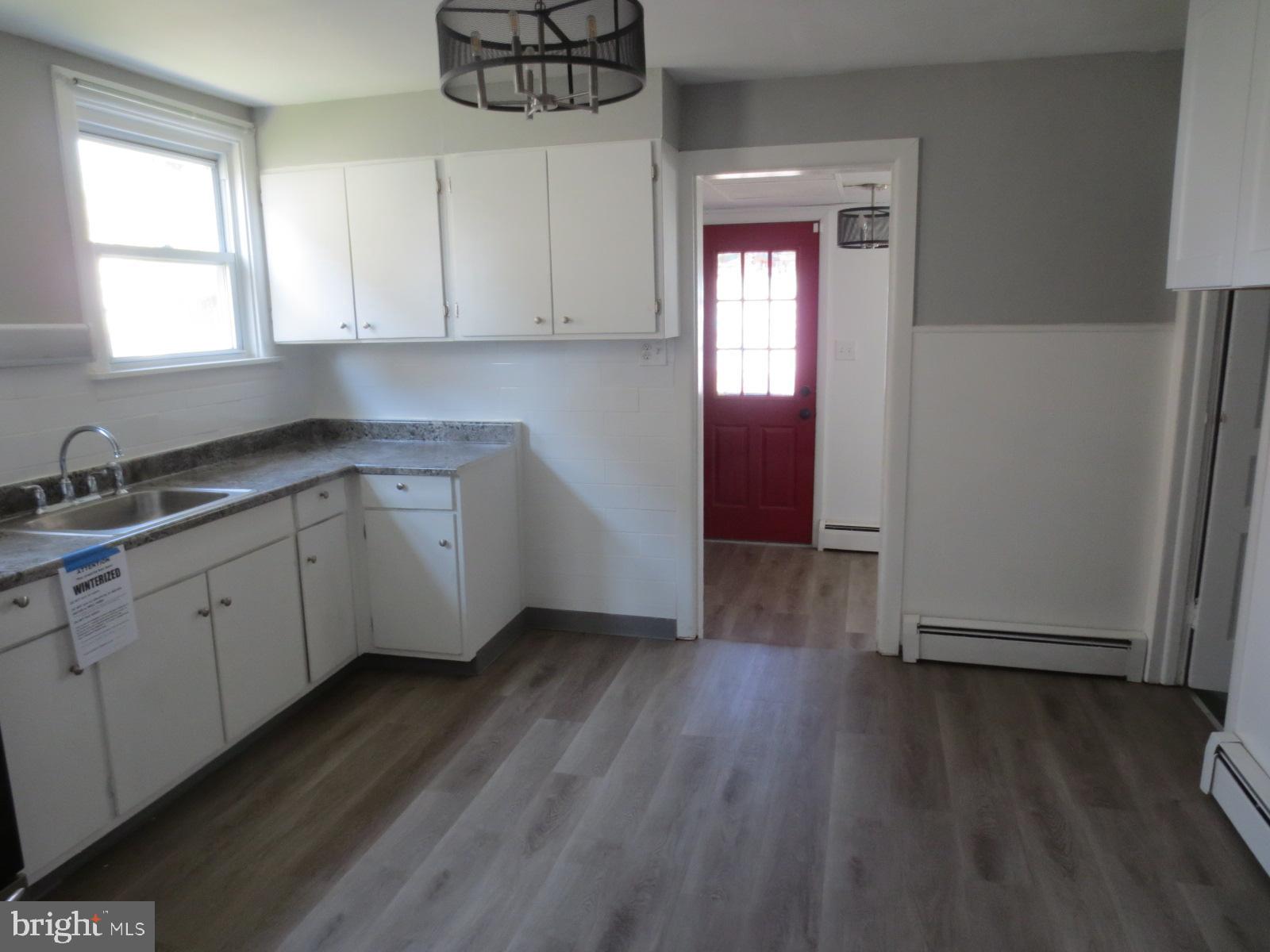 617 Benson Street Philadelphia, PA 19111 - Photo 37 of 37 a kitchen with wooden floors and white cabinets