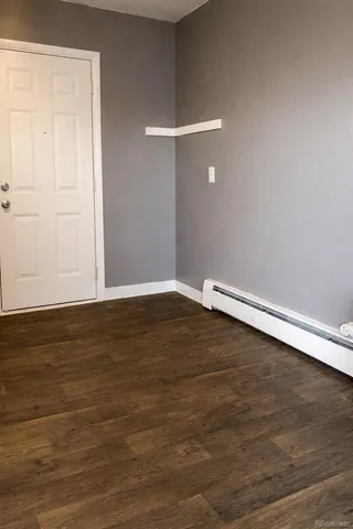 a view of an empty room with wooden floor